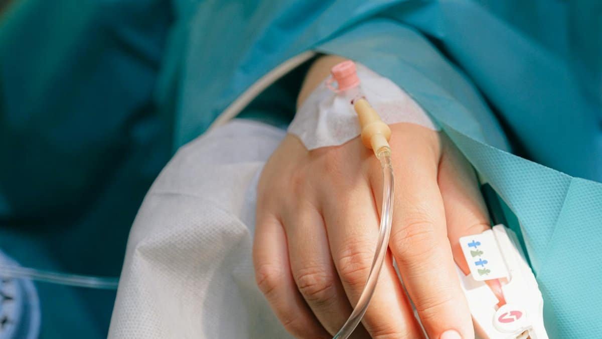 Close-up of a patient's hand with intravenous therapy and pulse oximeter, symbolizing healthcare and treatment.