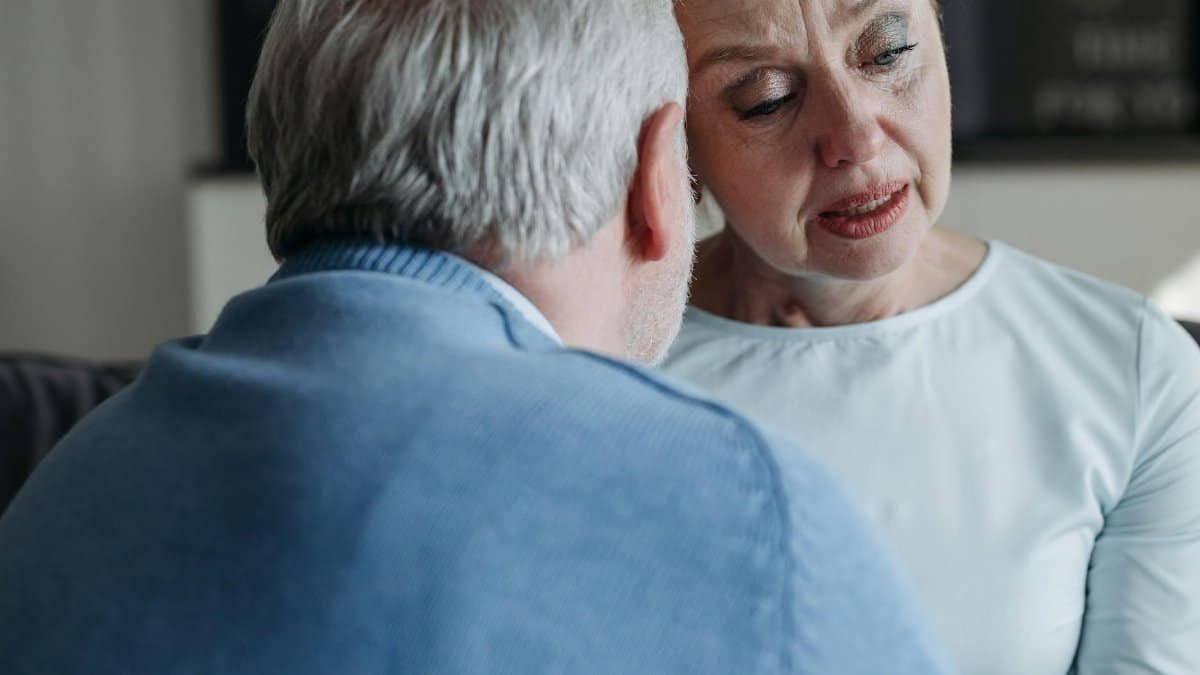 A senior couple sharing an emotional moment, showing support and empathy indoors.