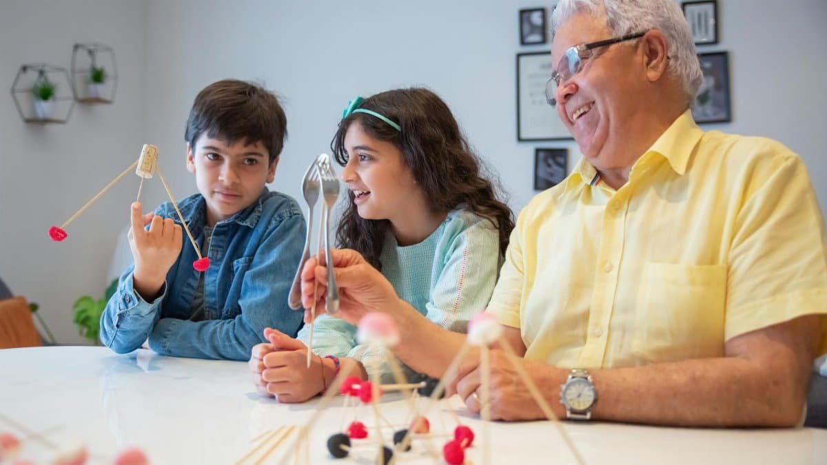Grandfather enjoying a creative and fun afternoon with grandchildren using building sticks.