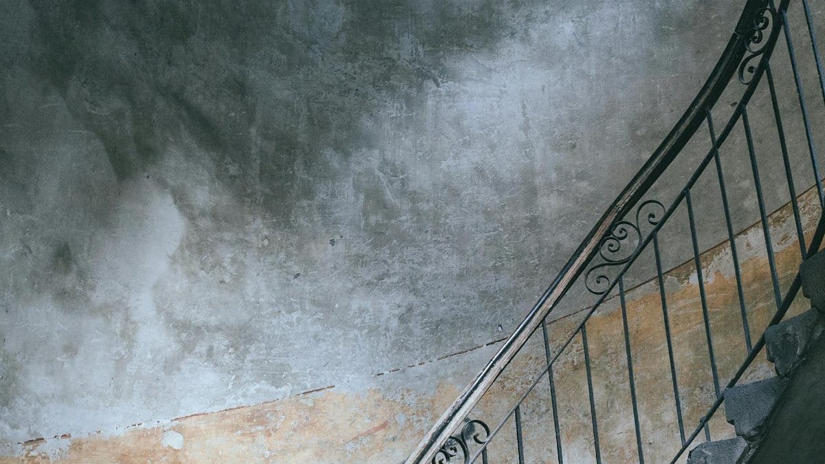 Stairway with metal railings and old shabby walls in porch of dwell building in city