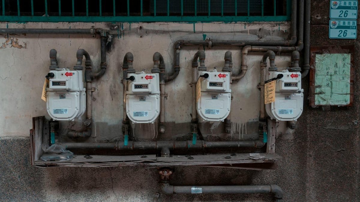 Four gas meters mounted on an exterior wall, showcasing urban utility infrastructure.