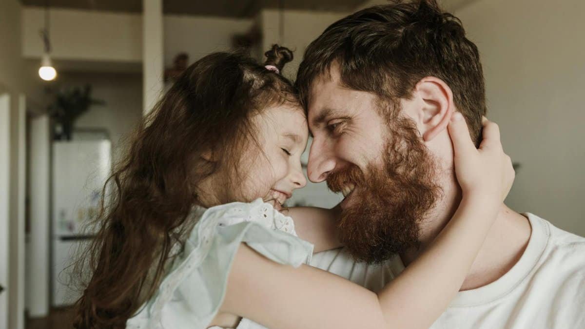Heartwarming moment of a father and daughter embracing indoors, showcasing love and happiness.