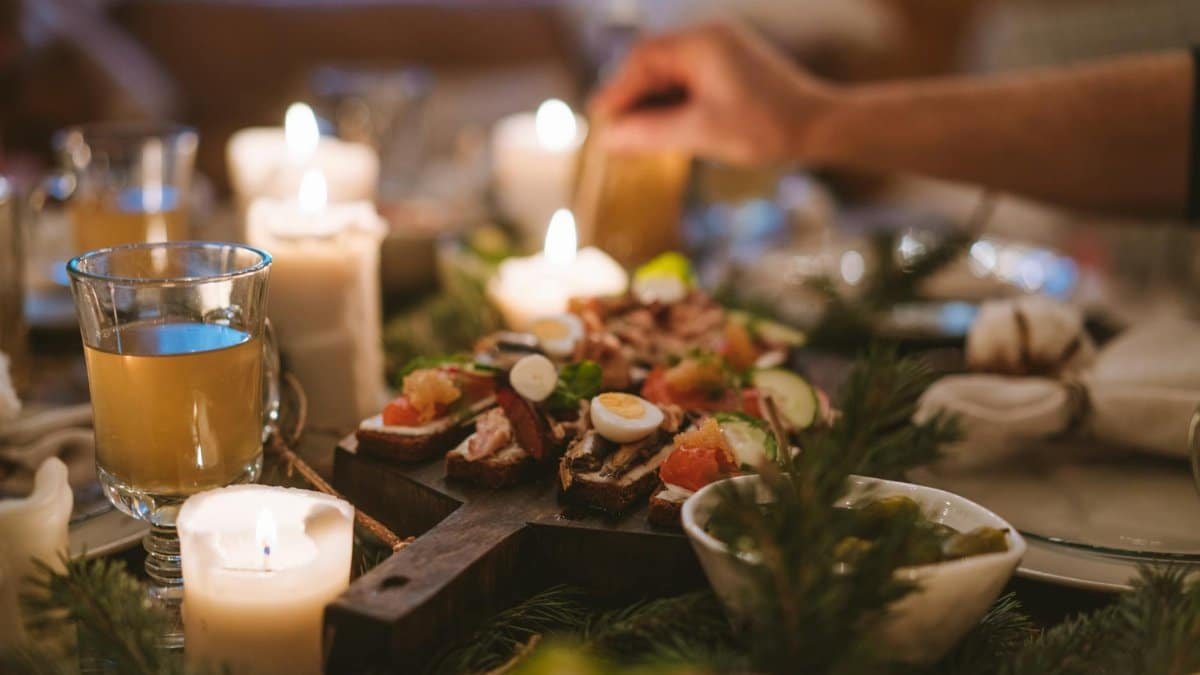 A cozy holiday dinner setting featuring candles, festive food, and a warm atmosphere.
