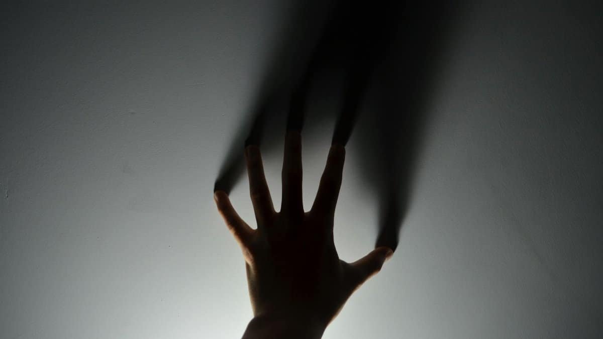 A mysterious silhouette of a hand casting a shadow on a wall, evoking an eerie atmosphere.