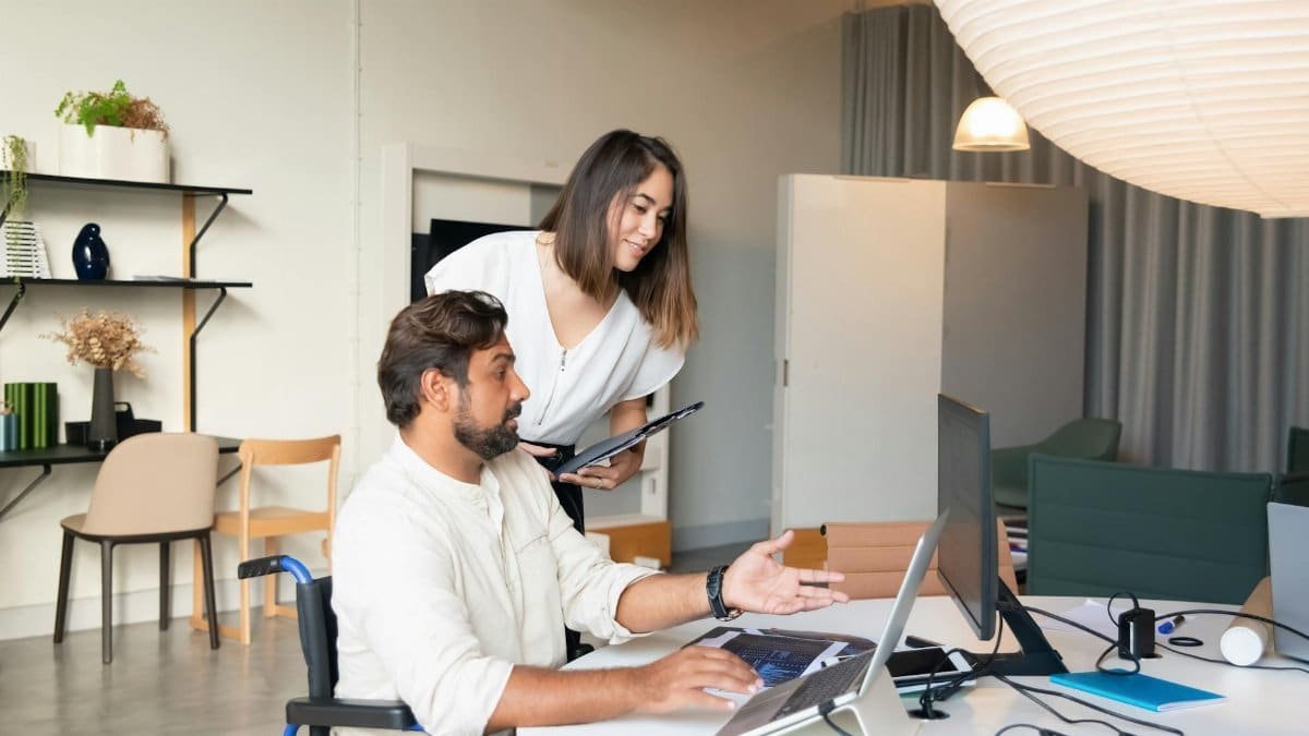 Diverse coworkers collaborating on a project in a modern office space with accessible facilities.