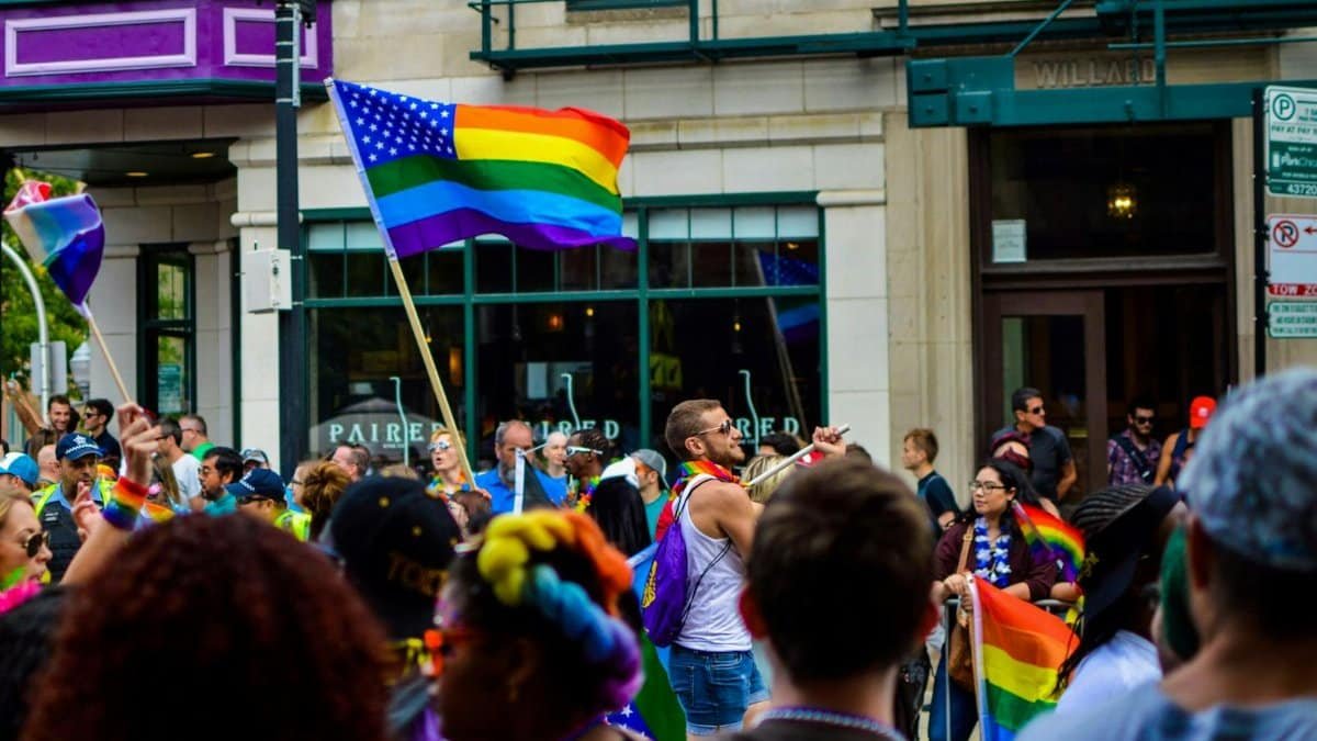 Vibrant Pride parade on a Chicago street with diverse attendees and rainbow flags waving.