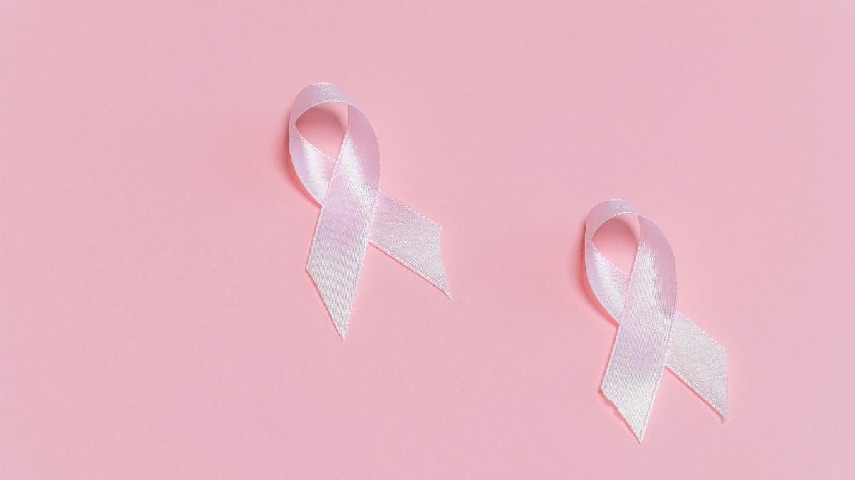 Pink ribbons symbolizing breast cancer awareness on a pink background.