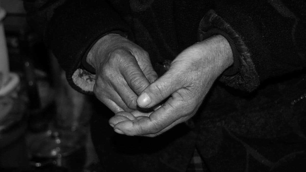 Close-up of elderly hands, weathered and expressive, captured in black and white.