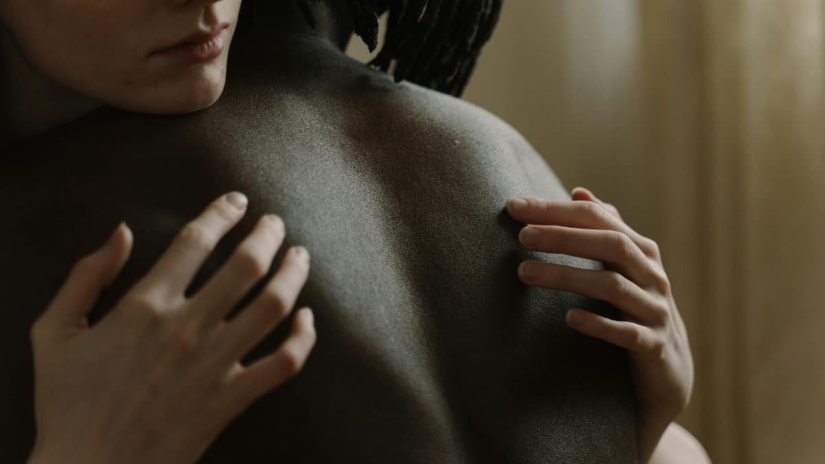 Close-up of an interracial couple embracing, symbolizing love and intimacy.