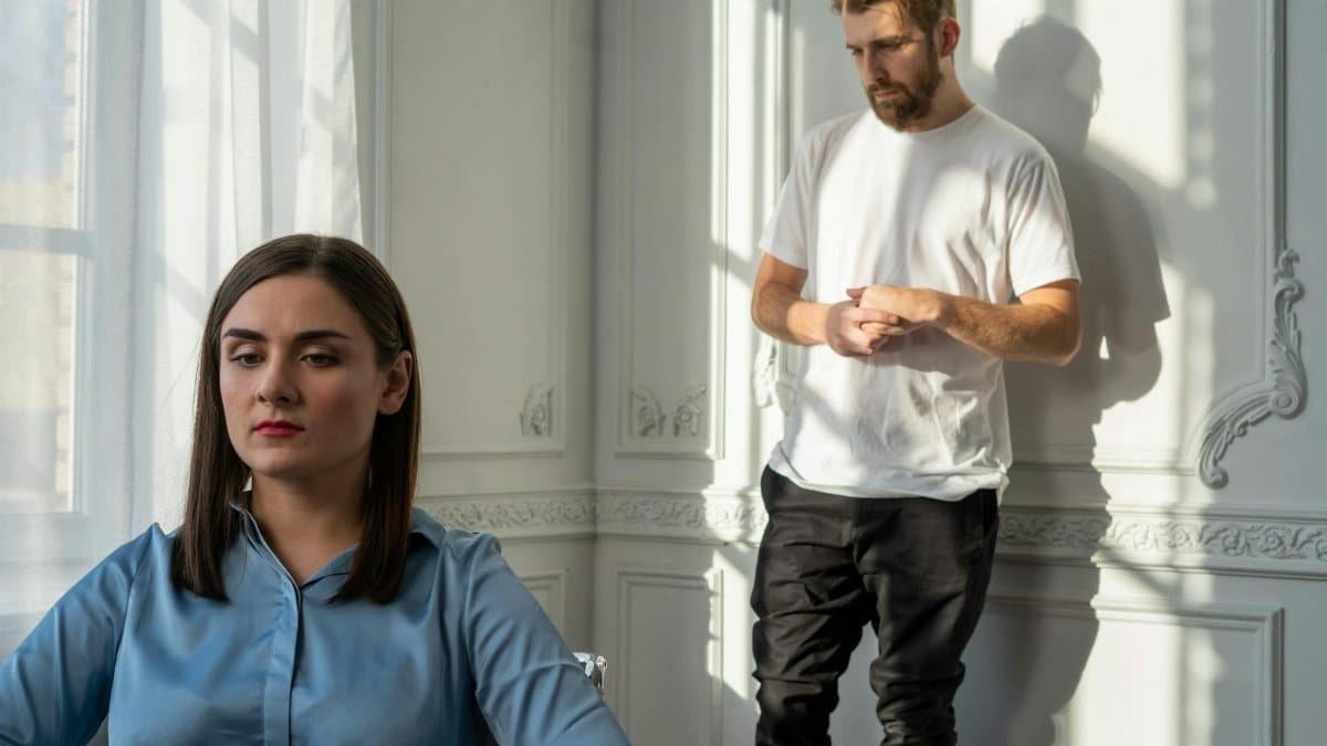 A couple struggles with emotional tension during a counseling session.