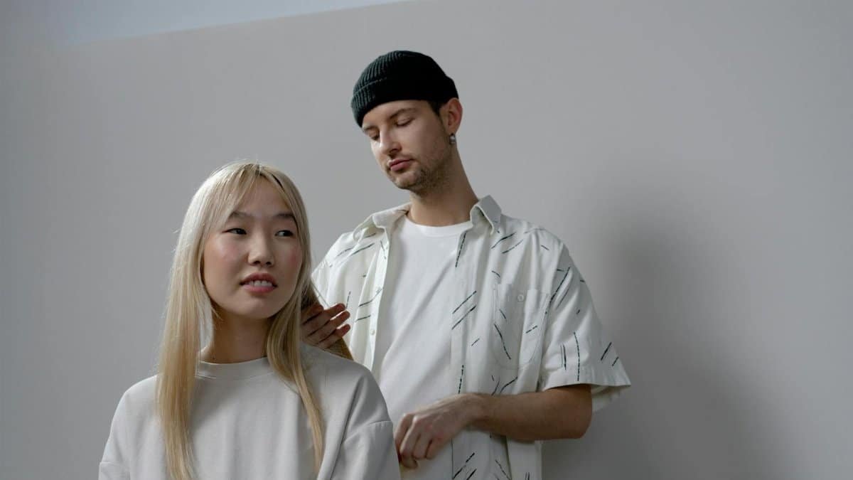 Asian woman gets stylish haircut from male hairdresser in modern salon.