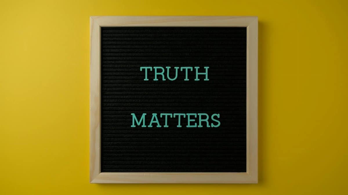 Close-up of black letter board with 'Truth Matters' message on yellow background.