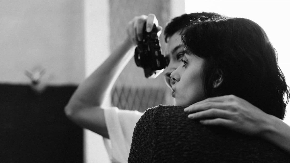 Intimate moment captured in grayscale of a couple with a vintage camera.
