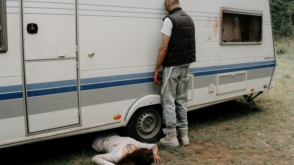 A foreboding zombie scene set next to a caravan, perfect for horror themes.