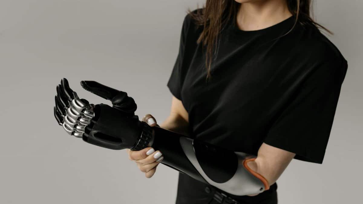 Close-up of a woman adjusting her cutting-edge bionic prosthetic arm, showcasing innovation.