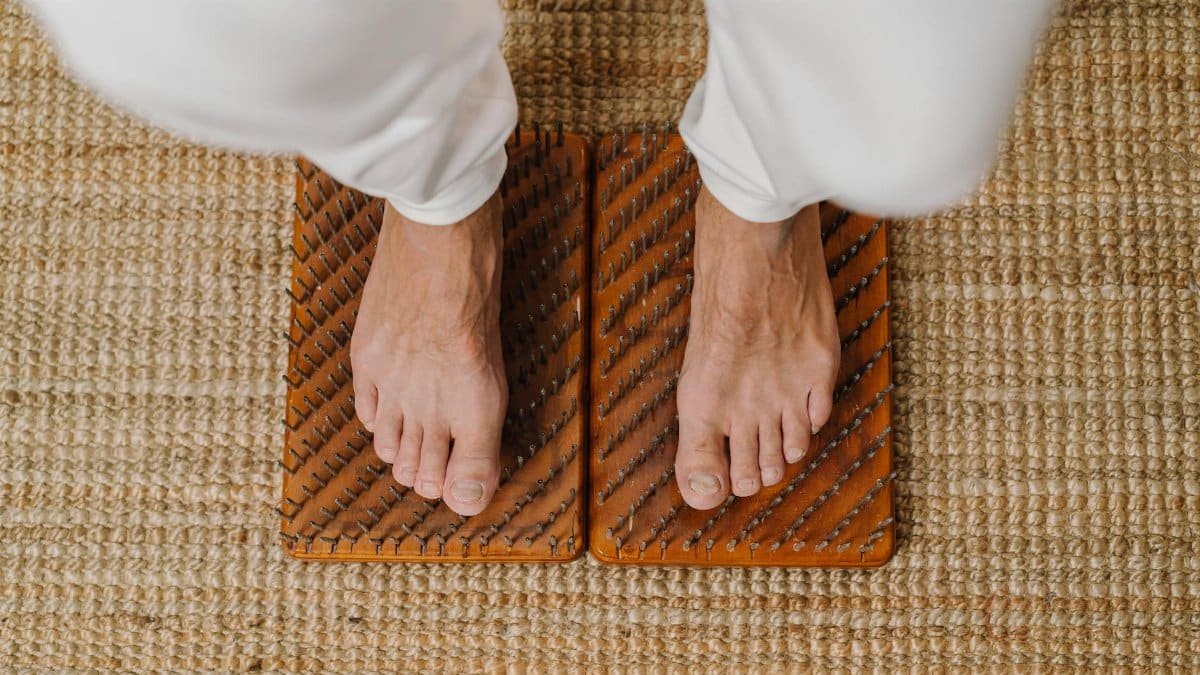 Close-up of feet on an acupressure board for holistic wellness practice.