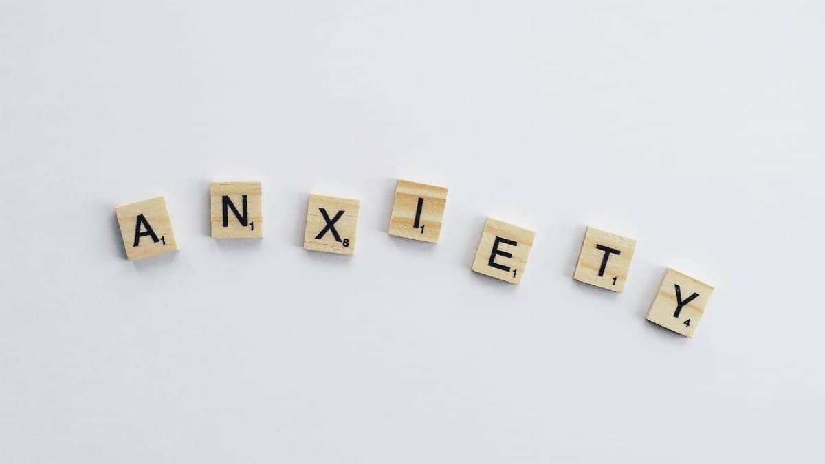 Wooden tiles on a white background spell anxiety, symbolizing mental health awareness.