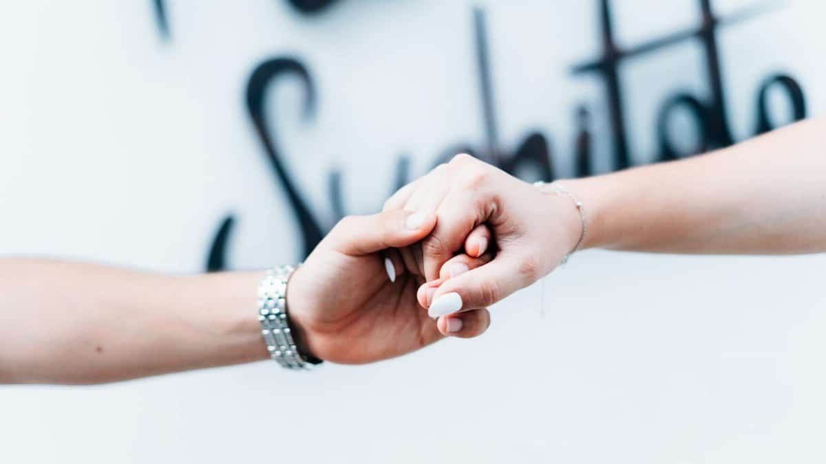 A tender close-up of a couple holding hands with a soft focus background, symbolizing love and unity.