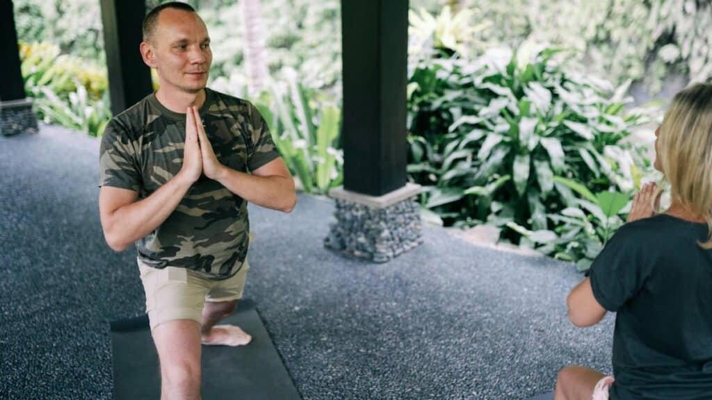 Man and woman engaging in yoga outdoors, focusing on relaxation and fitness.