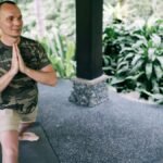 Man and woman engaging in yoga outdoors, focusing on relaxation and fitness.