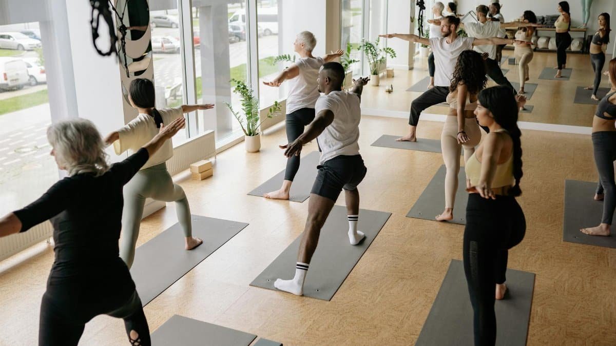 A diverse group of adults practicing yoga indoors, promoting wellness and mindfulness.