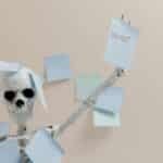 Humorous depiction of burnout with a skeleton holding sticky notes, representing overwork.