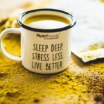 A motivational mug sits on vibrant turmeric powder, promoting relaxation and wellness.