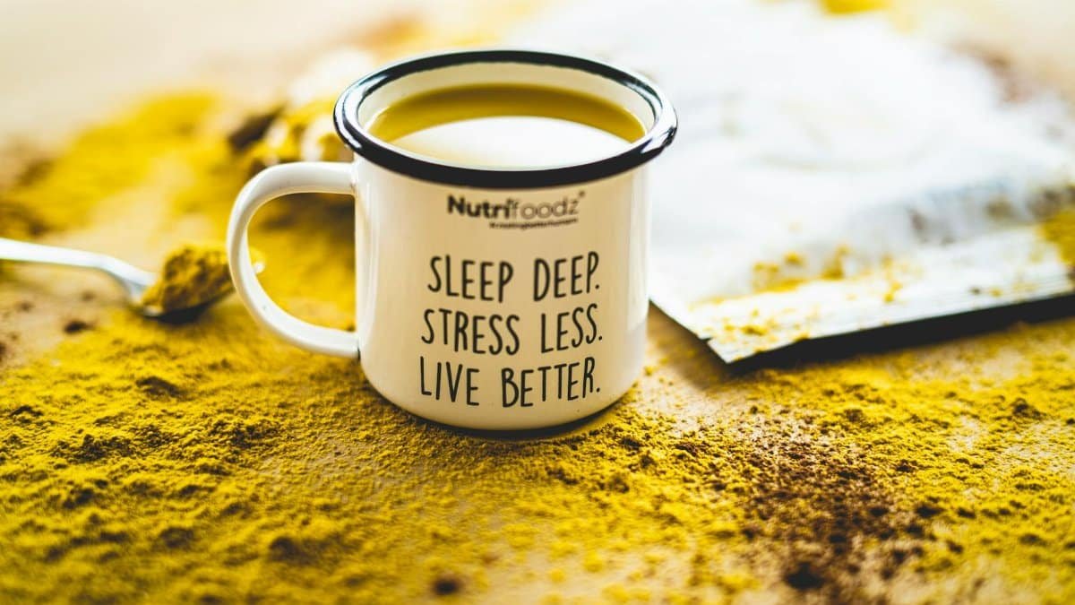A motivational mug sits on vibrant turmeric powder, promoting relaxation and wellness.