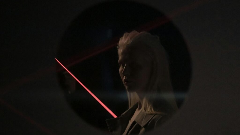 Mysterious portrait of a woman with neon lighting and reflections, evoking a futuristic mood.