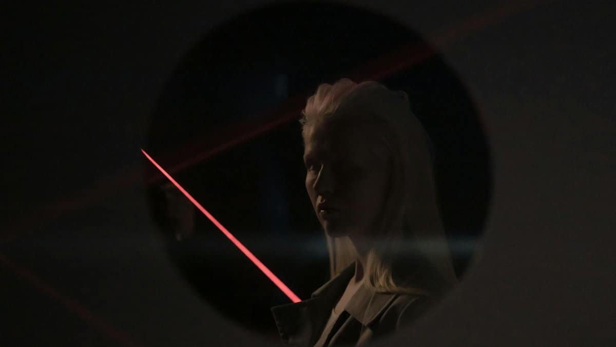 Mysterious portrait of a woman with neon lighting and reflections, evoking a futuristic mood.