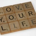Scrabble tiles arranged to spell 'Love Your Life' against a white background, conveying a positive message.