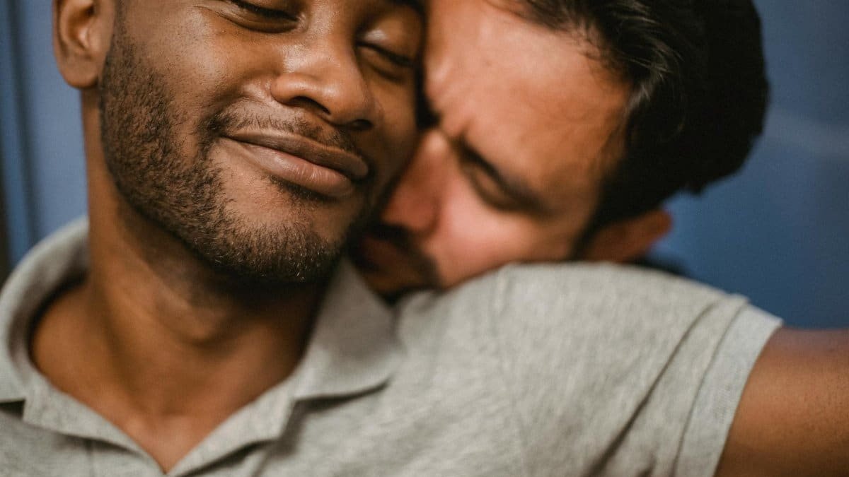 A close-up of two men sharing an affectionate embrace, expressing love and connection.