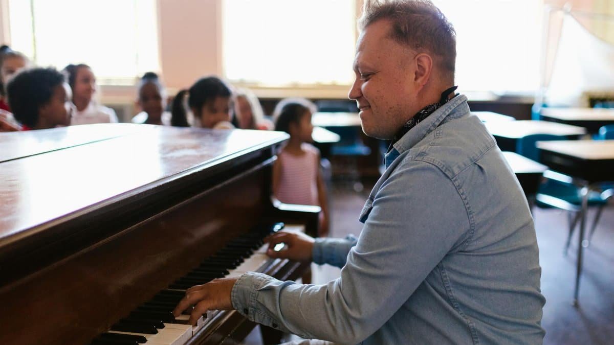Music teacher engages students with lively piano performance in classroom setting.