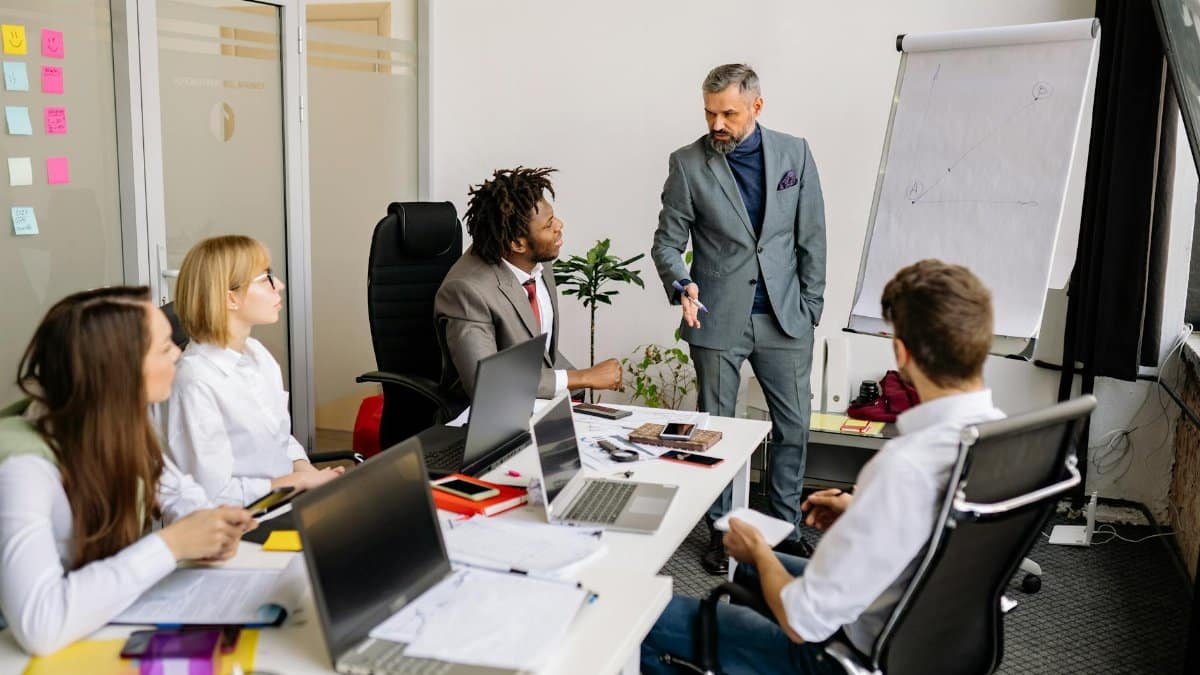 Corporate team in a modern office, engaged in a discussion with diverse colleagues.