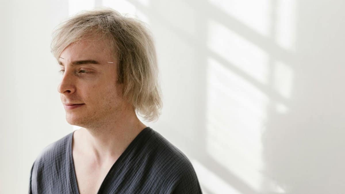 Caucasian man with acupuncture needle, embracing alternative therapy in a serene setting.