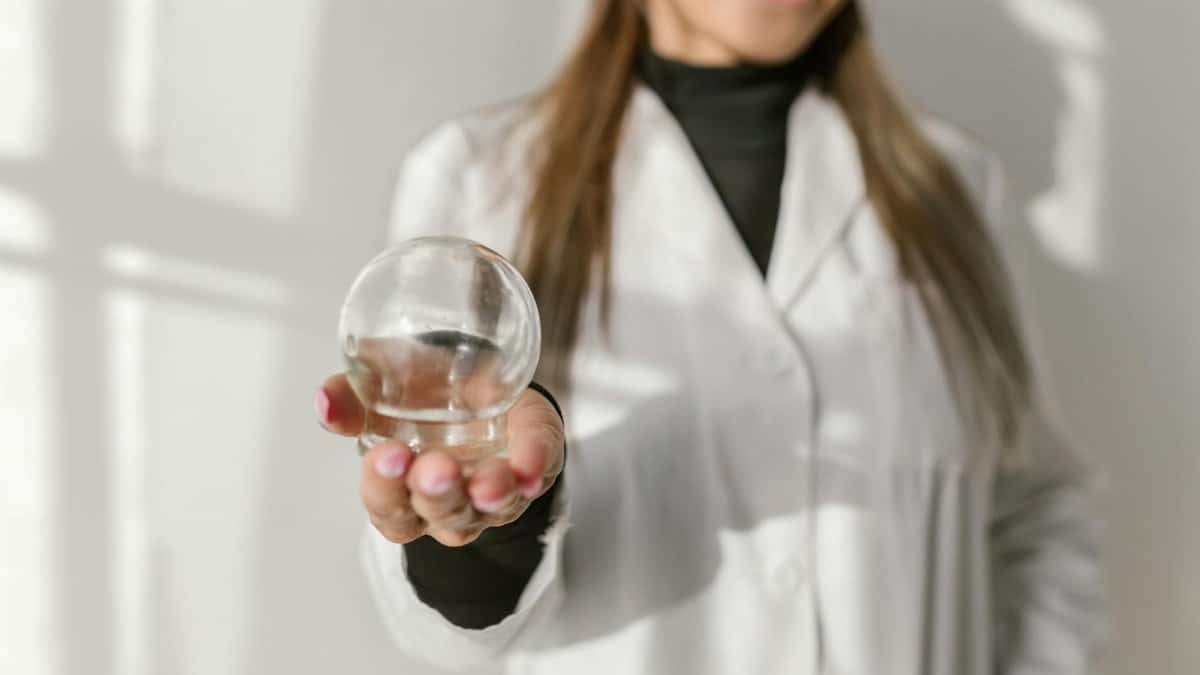 Close-up of a therapist holding a glass cupping tool, highlighting its use in alternative medicine.