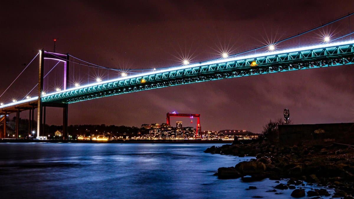 Vibrant long exposure of Gothenburg bridge lights reflecting over calm waters.