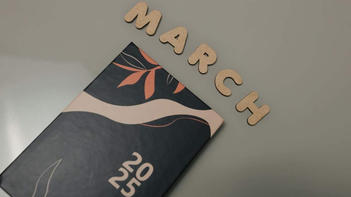 2025 planner with decorative cover alongside wooden March letters for design and planning concepts.