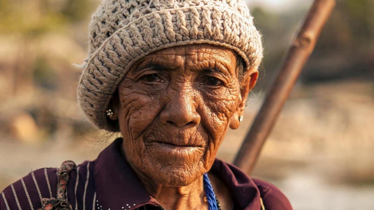 Close-up portrait of a senior woman wearing a wool hat, highlighting her wisdom and experience.