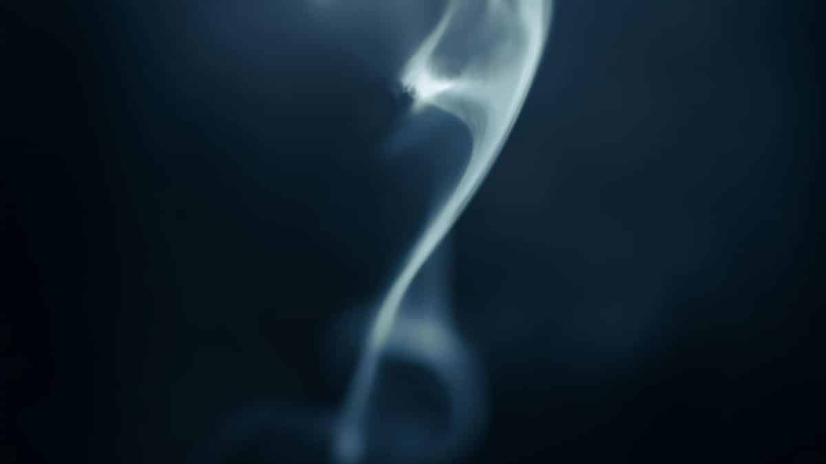 Enchanting abstract smoke swirl against a dark background, highlighting dynamic movement and contrast.