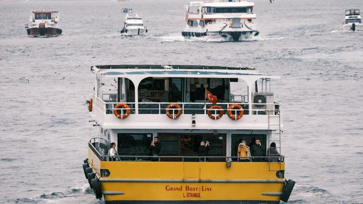Ferry boat cruising on the Bosphorus in Istanbul with passengers enjoying the view.
