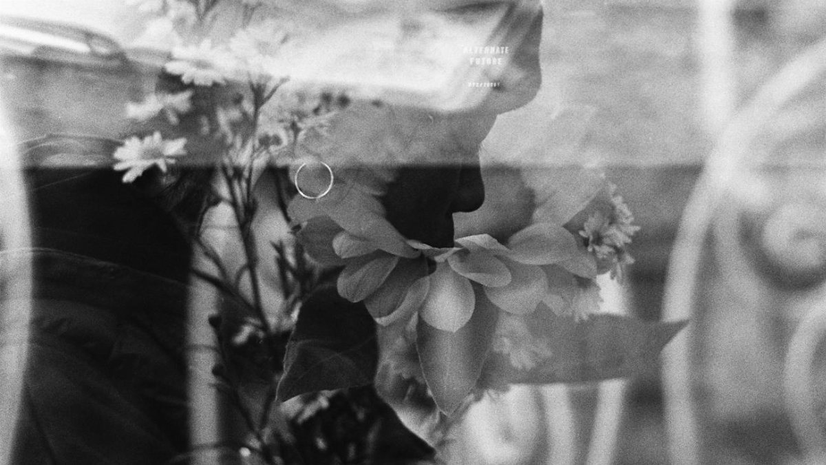 An artistic black and white photo with flowers and human form superimposed.
