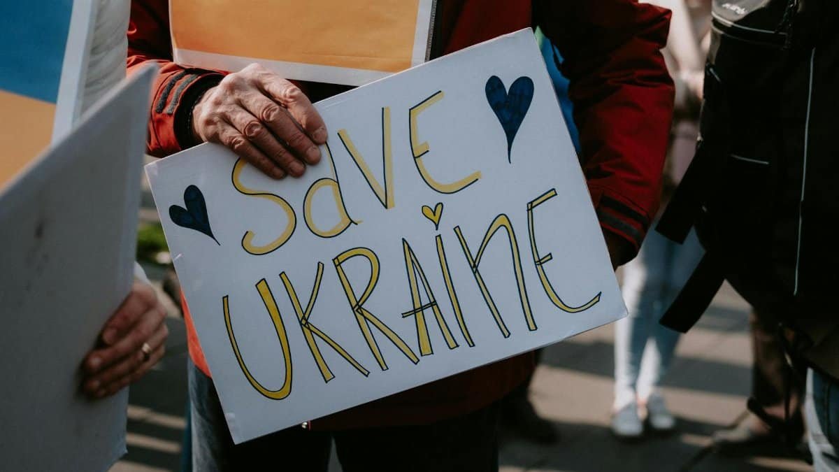 Protesters holding a Save Ukraine sign during a peaceful demonstration.