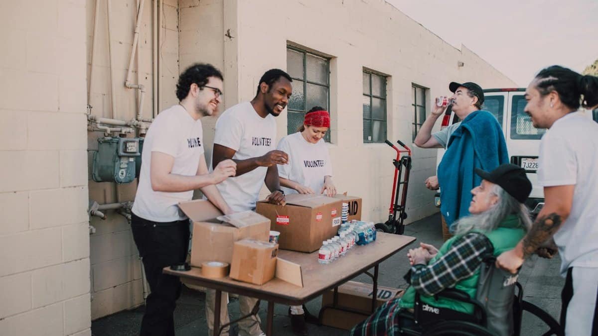 A group of diverse volunteers engaging in a community service activity outdoors, providing aid and support.