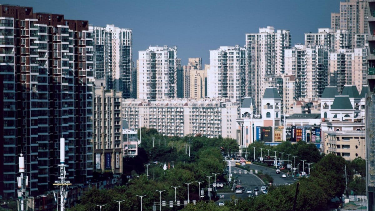 View of high-rise apartment buildings and busy city street with lush greenery.