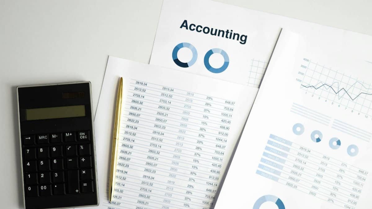 Calculator and accounting documents with charts on a workspace.
