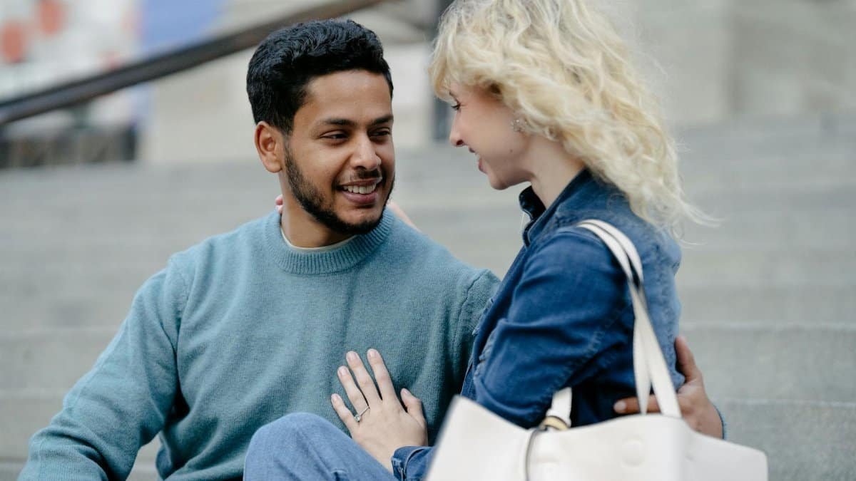 Cheerful couple enjoying a moment together on steps, radiating happiness.