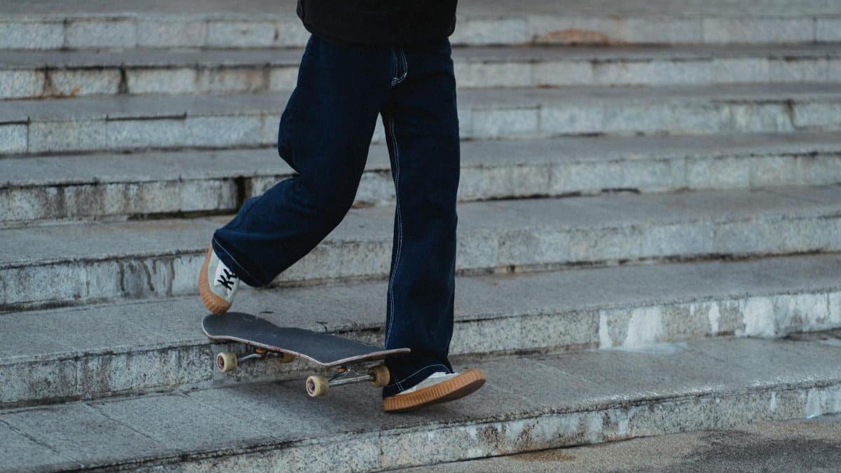 A skateboarder in motion performs tricks on concrete steps, showcasing urban street style.