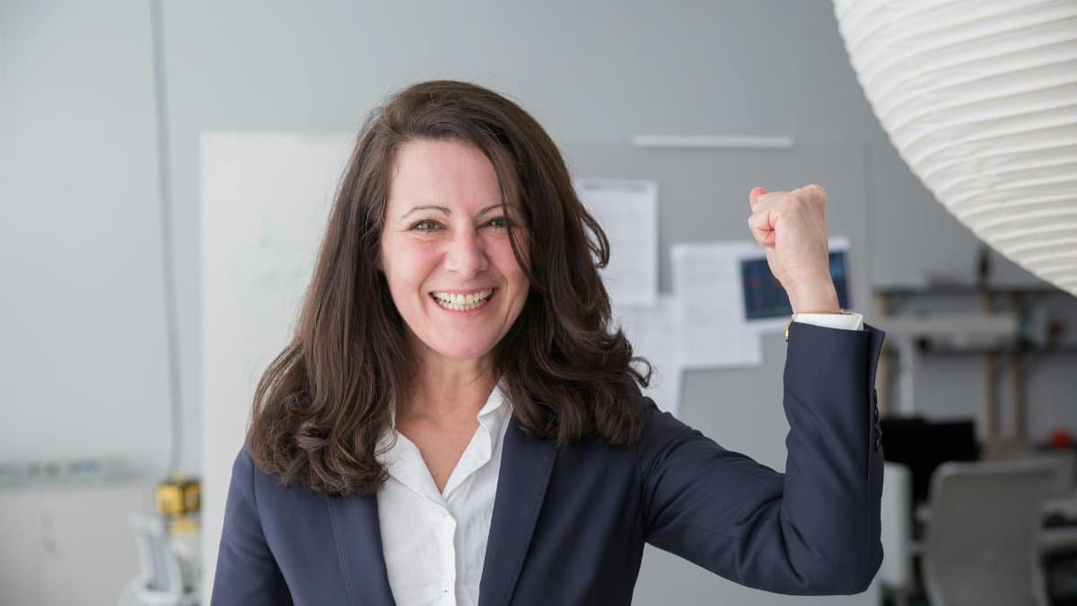 Smiling businesswoman in a smart suit celebrating a success in the office.