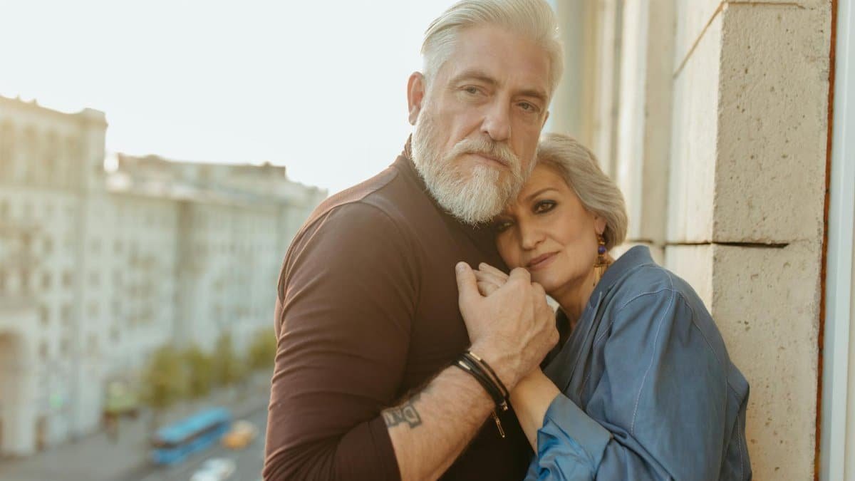 A senior couple embracing tenderly outdoors, showcasing love and connection.